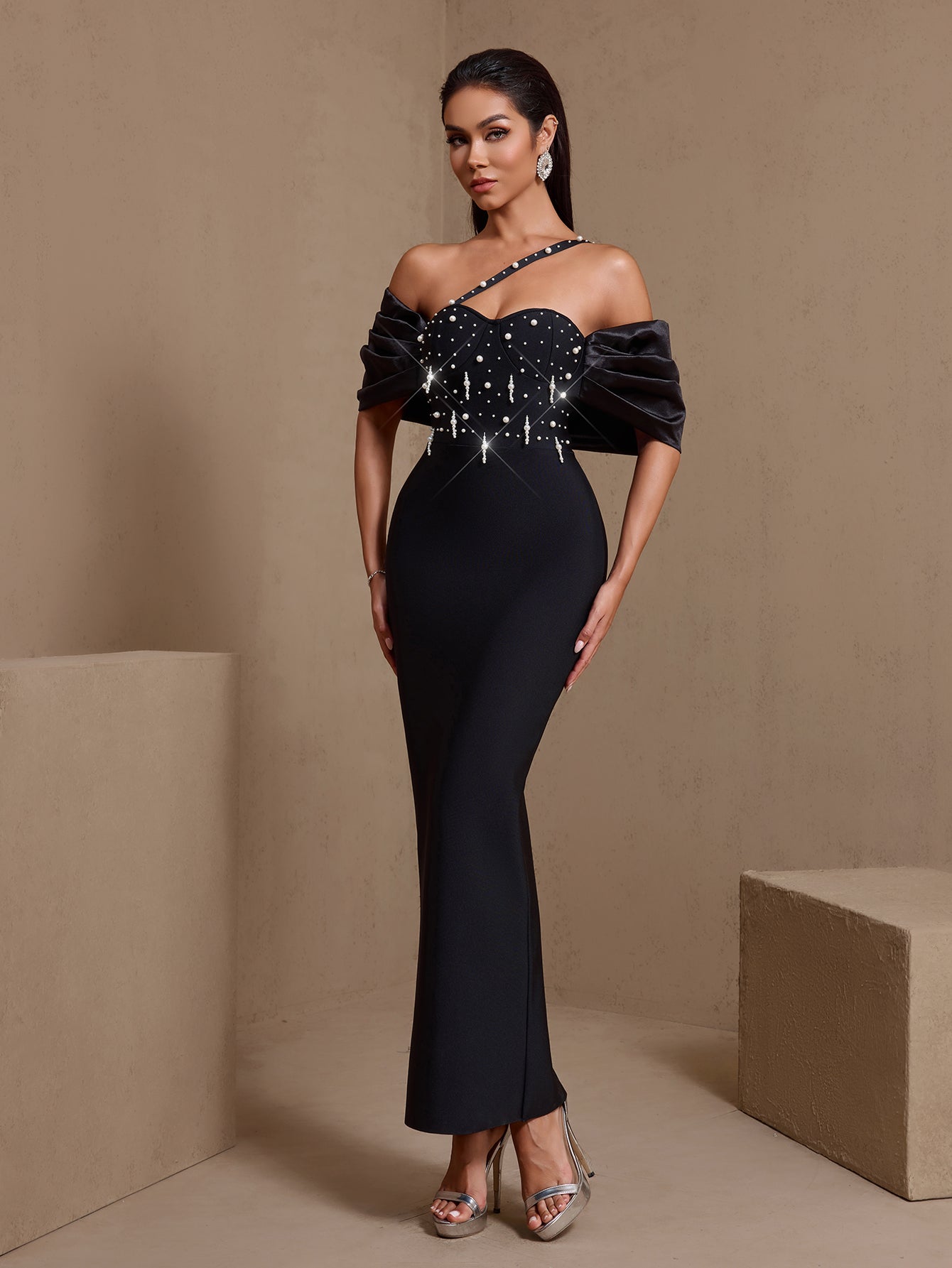 Black asymmetric pearl cascade bandage maxi dress, angled front view