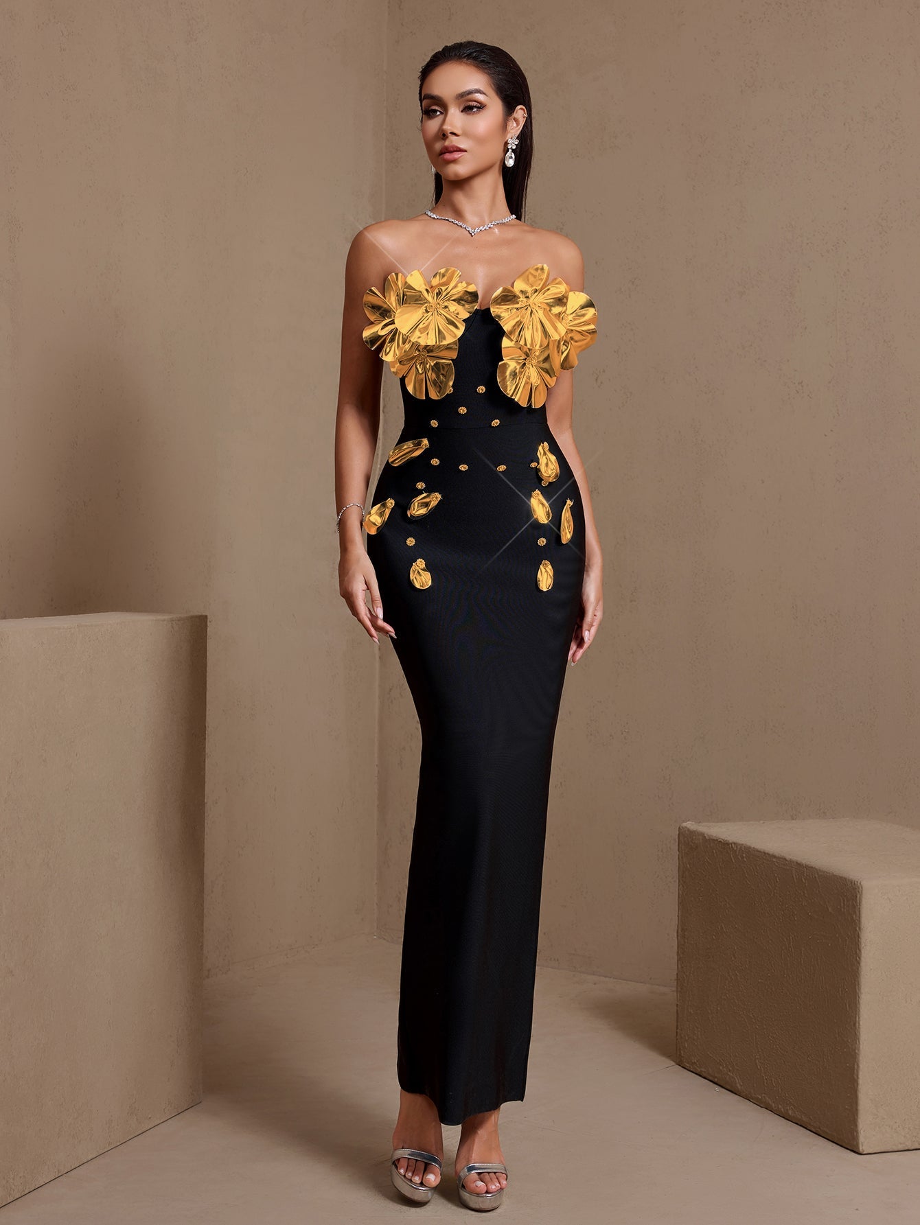Black and gold sculptural floral strapless bandage maxi dress, full-length front view