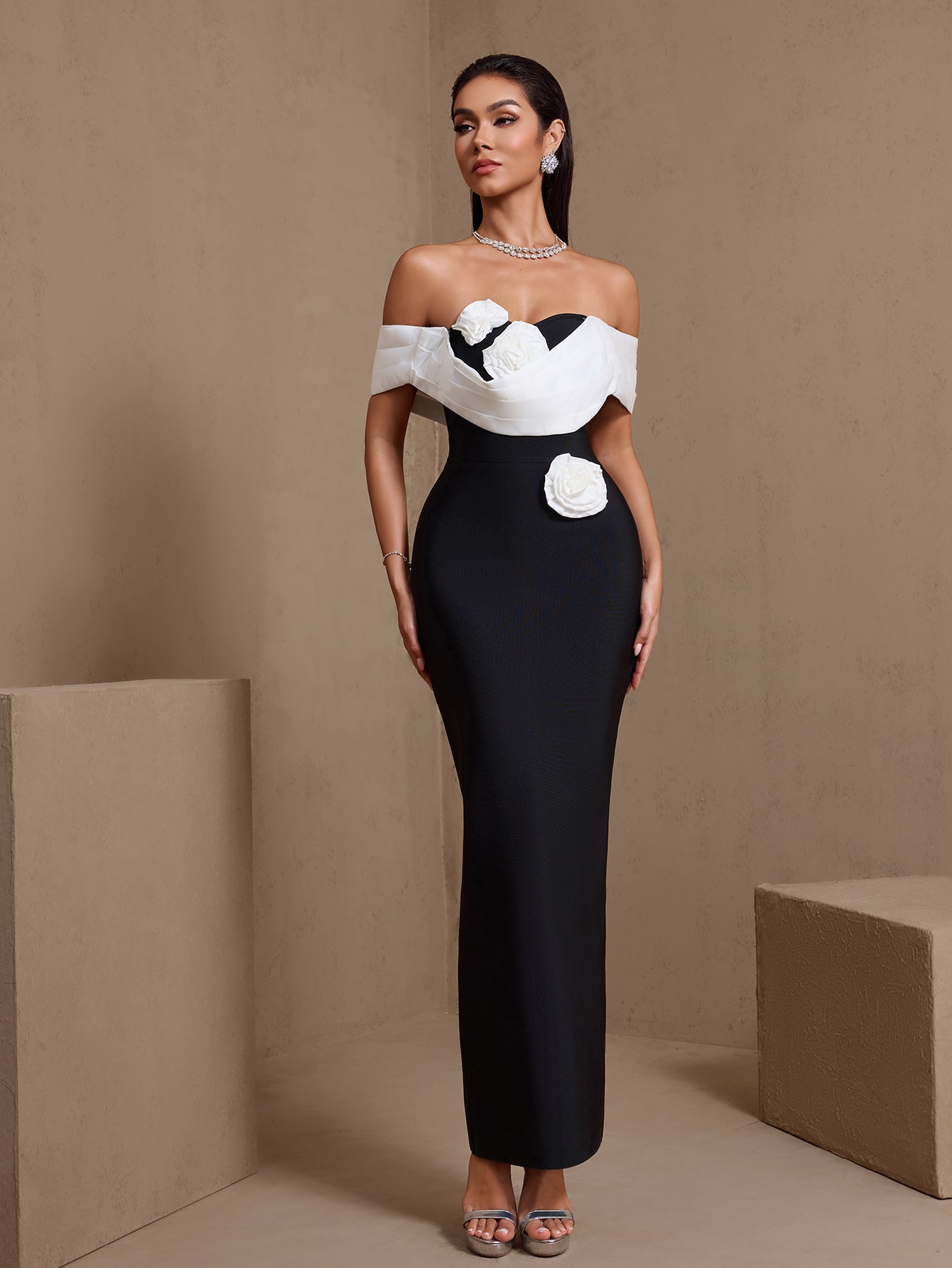 Black sculpted rosette off-shoulder bandage maxi dress, angled front view